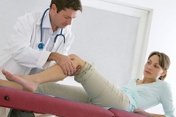 the doctor examines the legs after surgery for varicose veins